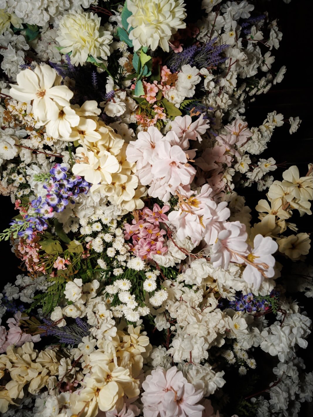 Detalhe de arranjo floral com flores brancas, rosas e lilases